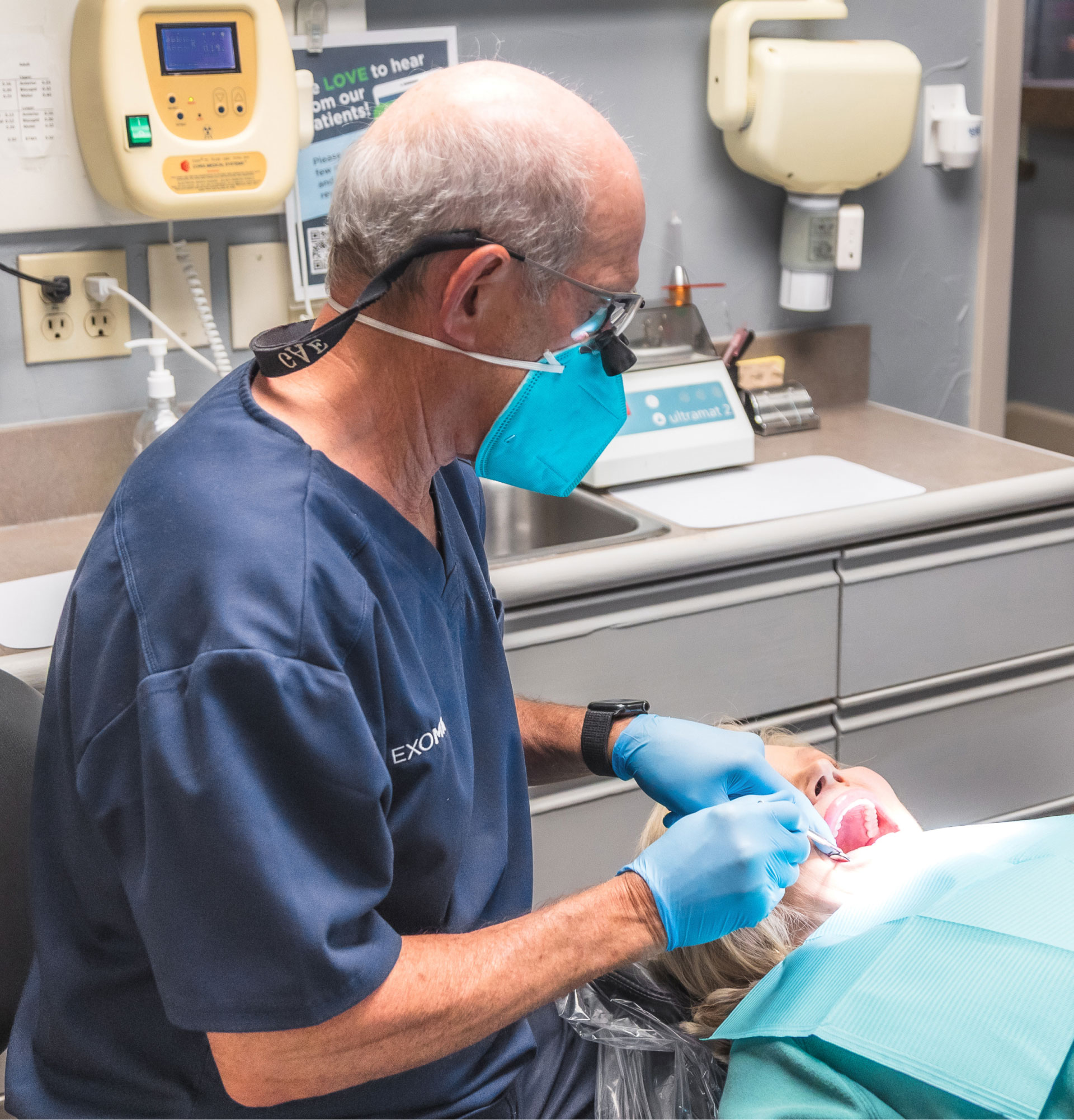 Dentist performing dental procedure on patient in exam room